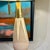 A modernist ceramic table lamp designed by Gerald Thurston. Cream and brown ceramic form with patinated brass base and...