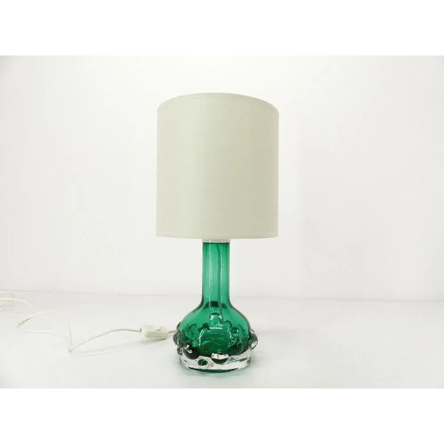 Brutalist lamp in thick emerald green translucent glass, designed by Hans-Owing Sandeberg for Kosta. It is signed under...