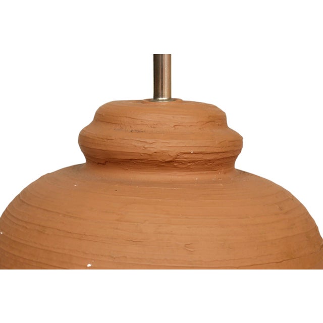 A postmodern table lamp. The traditional vase shaped body is plaster with a richly textured finish in an earthy terracotta...
