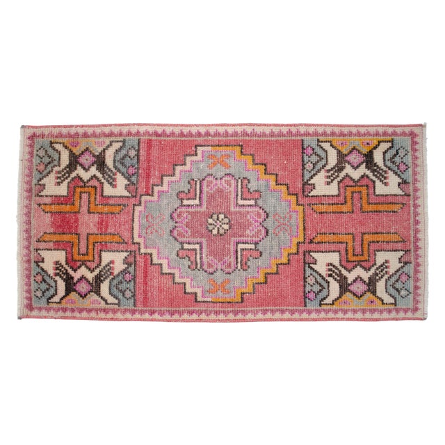 a Vintage Turkish Small yastik rug, pinkish red background rug perfect for entryway, bath or in front of the kitchen sink....