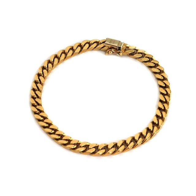 This authentic vintage curb link bracelet is crafted in solid 18k yellow gold and features a classic interlocking curb...