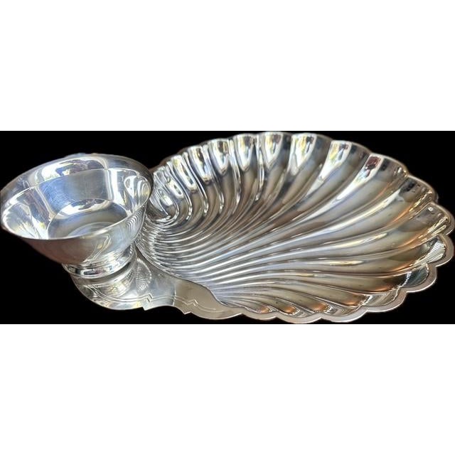 Vintage W.M. Rogers silver-plated clamshell shape serving dish featuring a built-in dip cup, finished in a scalloped shape...