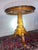 Elegant traditional pedestal accent table featuring a round black marble-look top with decorative stone border and a...