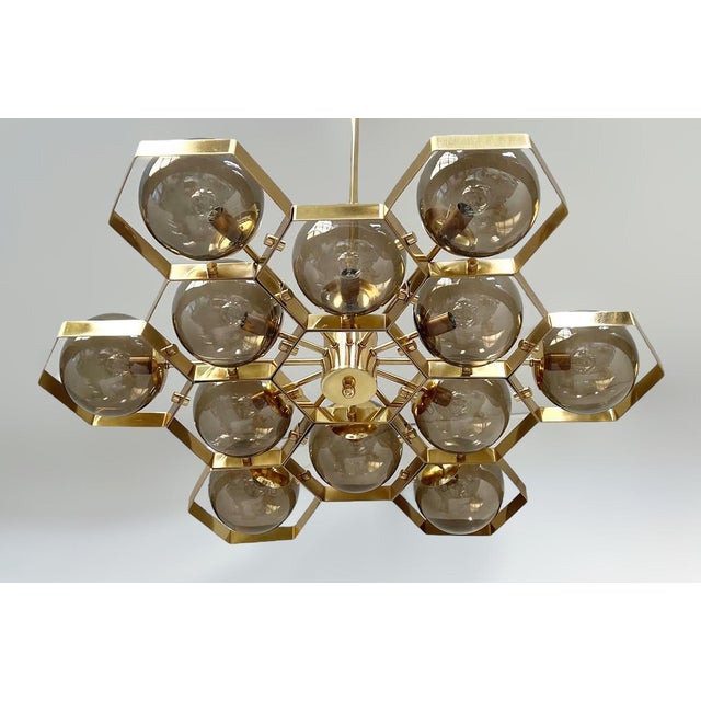 Italian modern chandelier with smoky Murano glass globes, mounted on solid brass frame in lacquered polished brass finish...