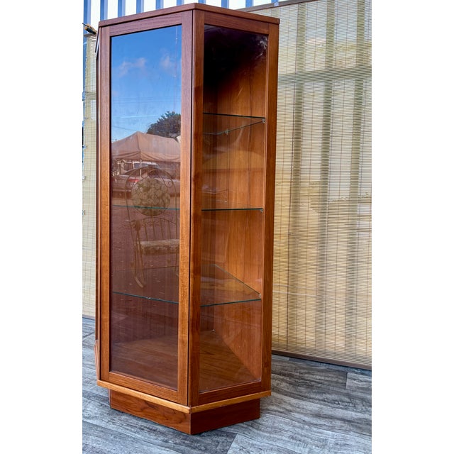 Vintage Mid-Century Modern Danish Lighted Corner Curio Display Cabinet by Komfort Denmark. Circa 1970s Features a clean...