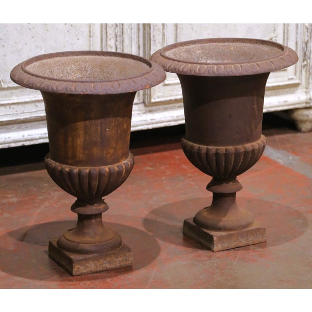 Decorate a garden, entry, or interior vignette with this elegant pair of antique French Medici urns, crafted circa 1860....