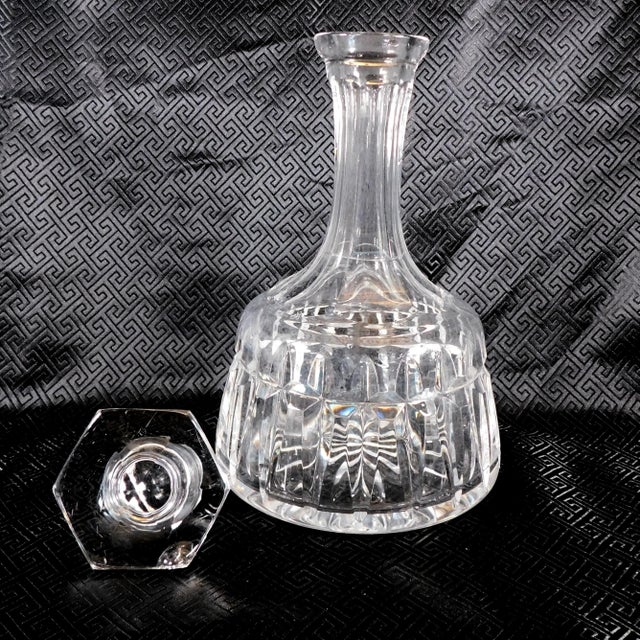 This is a shorter cut crystal decanter with a flat shaped six sided stopper. The decanter has no markings that I could...