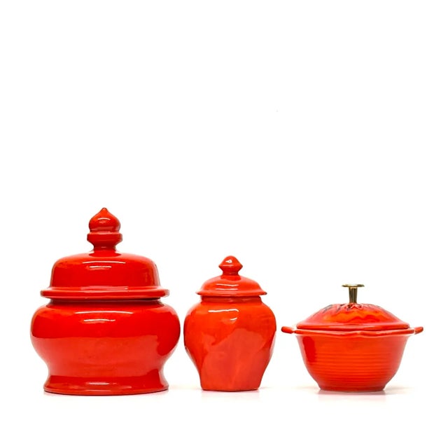 Red lidded containers, group of 3. Eclectic red ceramic lidded containers from the mid-20th century, in assorted shapes...