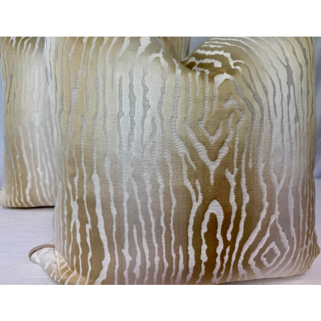 Custom pair of 22" pillows covered in Thibaut "Traduzione" in color cream and corded in a Samuel & Sons beige decorative...