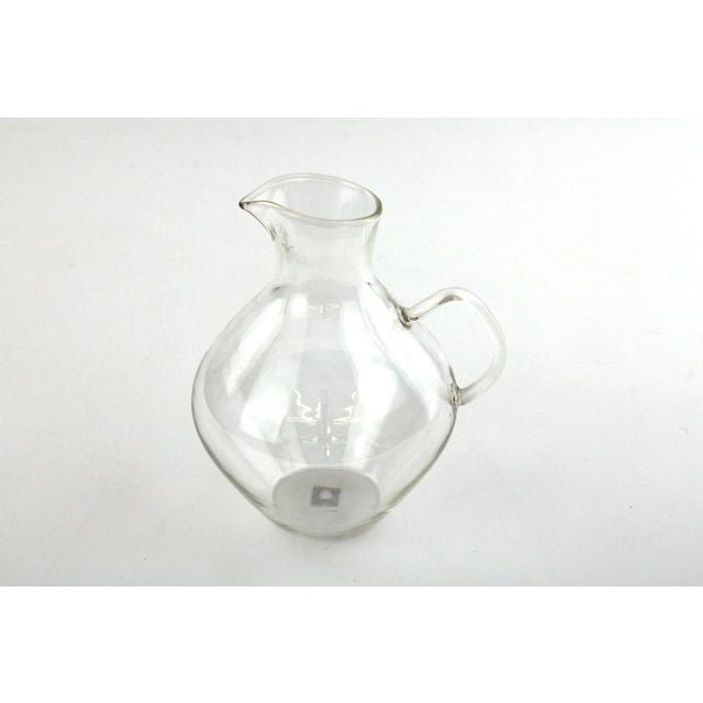 6 teacups with saucers, made of fireproof glass, plus a small handle jug for milk. This piece has an attribution mark, I...