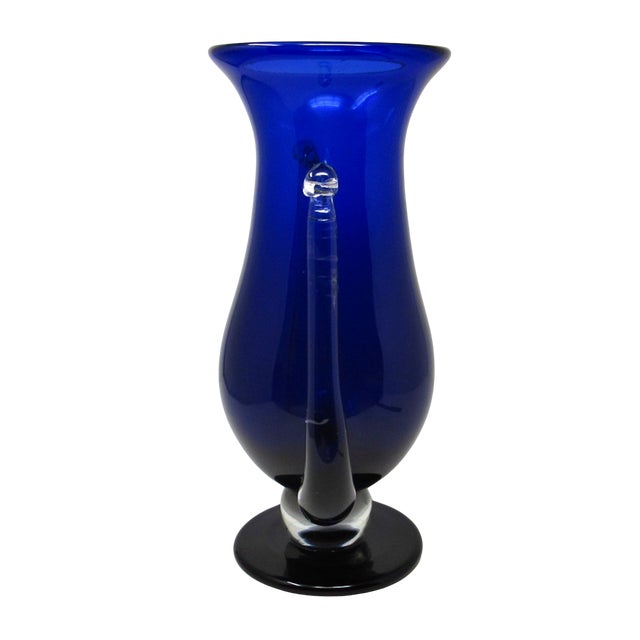 Glass artist Steven Correia designed and created this blue glass trophy vase in 1990. The hand-blown vase has two clear...