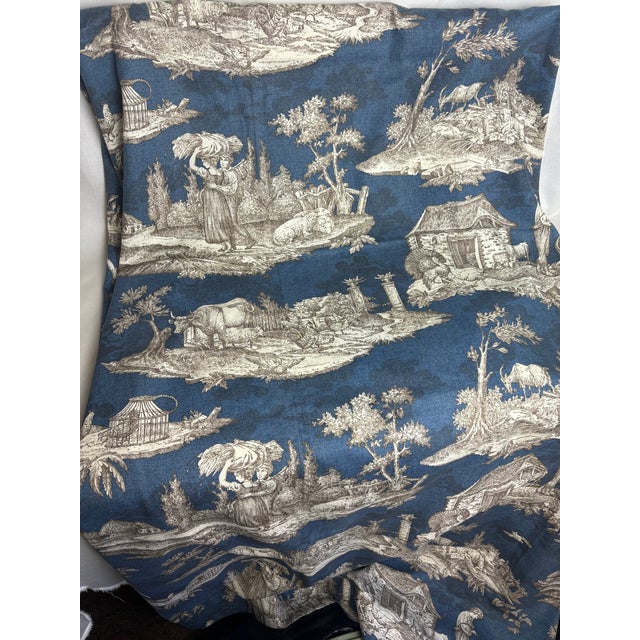 This Williams Sonoma textile is a lovely traditional toile print. The images depict a country scene between two figures.