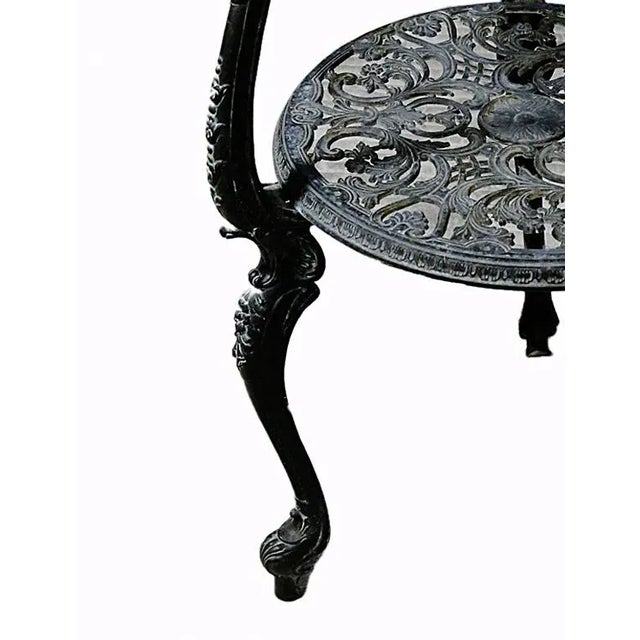 Late 20th century, traditional, round black painted, ornate iron two tiered table.