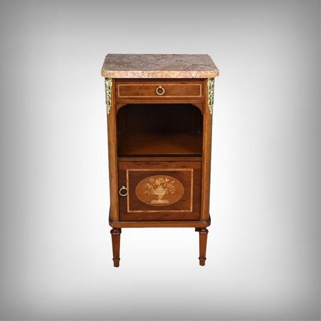 This elegant small Louis XVI cabinet, crafted from marquetry of oak and mahogany, captivates with its balanced proportions...