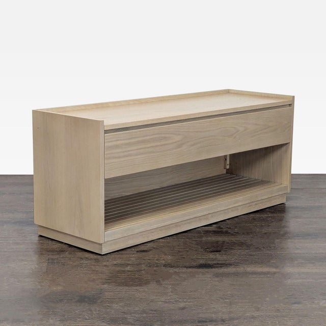 The bench has a white oak finish and slatted detailing. Made for storage, the bench also features a pullout drawer and an...