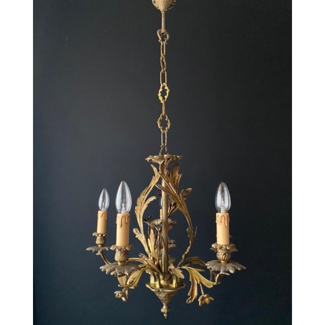 The chandelier is made of bronze. It’s adorned with beautiful flowers—they look just like the real thing! Exquisite and...