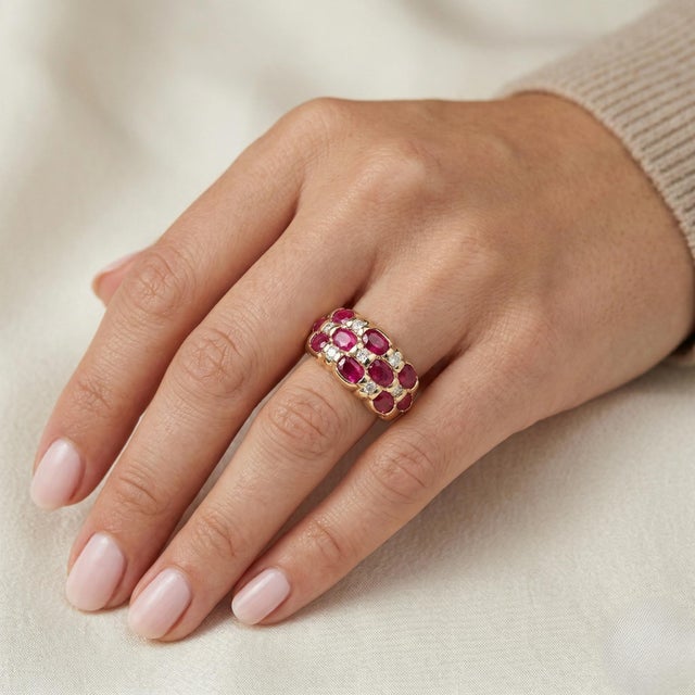 Elegant 14K yellow gold ladies ring featuring a rich oval ruby center accented by natural diamonds totaling 0.20 Carat...