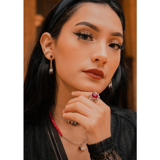 Beautiful Art Nouveau design ring features a red oval cushion cut natural ruby framed in a beautiful floriated halo of...