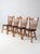 A set of four vintage spindle back dining chairs crafted in warm wood tones with turned legs and a classic silhouette. The...