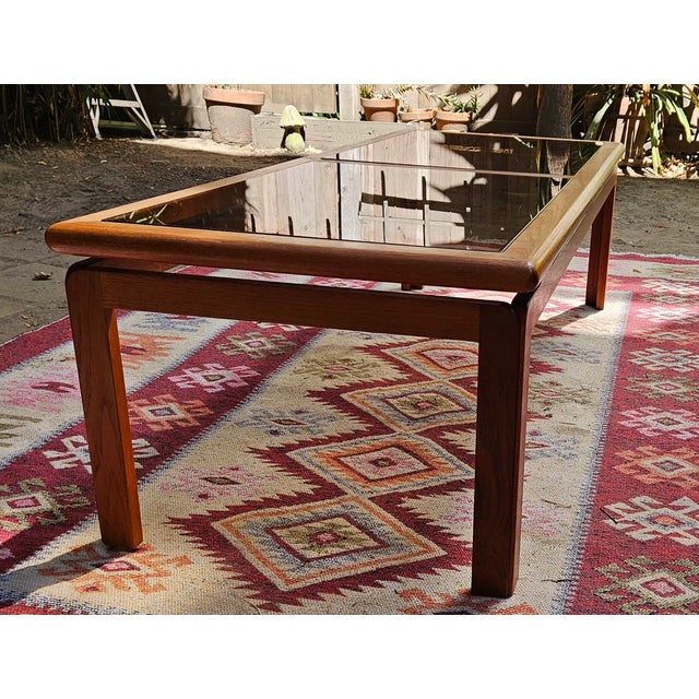 Beautiful vintage MCM Danish modern coffee table made in Denmark by Kristiansen Thomassen from solid teak with two smoked-...