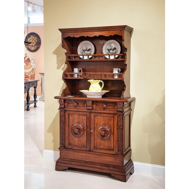 Antique Italian Tuscan buffet and hutch handcrafted from solid walnut. The upper hutch features open display shelves with...