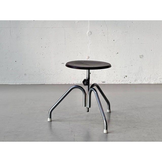 A distinctive industrial stool from the 1970s with a clean, functional design. The round seat, made of dark-stained...