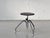 A distinctive industrial stool from the 1970s with a clean, functional design. The round seat, made of dark-stained...