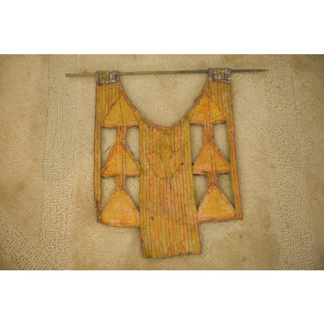 A strange, suspended composition combining embroidered textiles, triangular mirror inlays, and polychrome metallic...