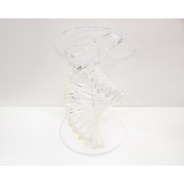 A vintage acrylic pedestal. This pedestal has a twisted spiral design at its center formed from blocks of stacked acrylic....