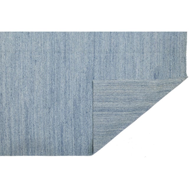 Anchor your space with the tranquil elegance of this modern Denim Blue Flatweave Rug. Hand-woven with care, this rug is...