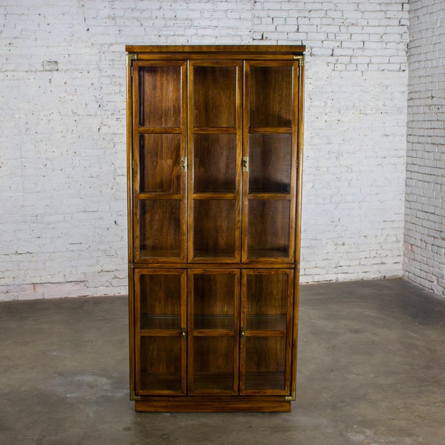 Handsome vintage Campaign style oak lighted curio cabinet by Drexel Heritage Accolade II Collection with glass shelves,...