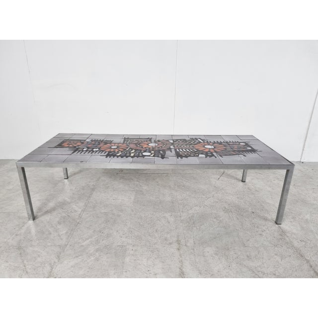 Mid-century ceramic tile coffee table by Belgian company Perignem. Beautifully decorated tiled table top with a chrome...