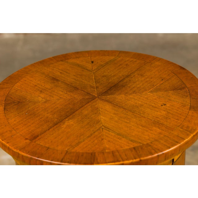 An Italian walnut drum table from the 19th century with bookmatched top, single door and single drawer. This 19th-century...