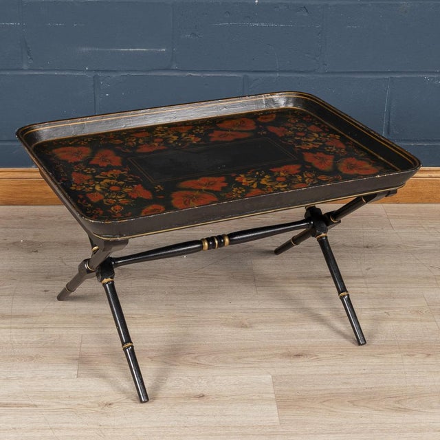 A charming occasional table made out of two components. A large tray decorated with flora and gold detailing sits over a...