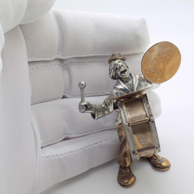 A highly collectible silver and brass figurine of a circus performer with drums, handcrafted by renowned silversmith...