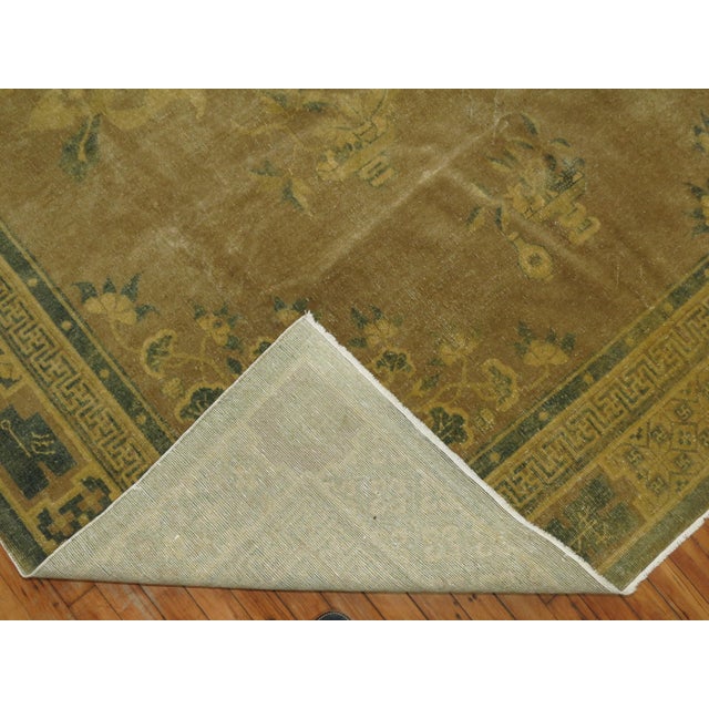 A mid-20th-century room size Chinese rug in soft brown and olive tones Measures: 7'10'' x 10'9''.