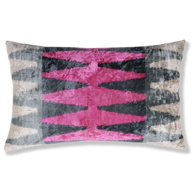 "This luxury silk velvet ikat lumbar pillow features a striking composition of vivid pink layered with charcoal gray and...