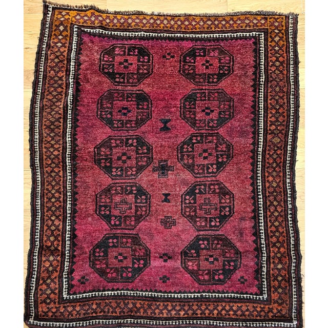 3’ 10” x 5’ 2” Vintage hand knotted Afghan area rug in a plum/deep burgundy color from the mid 1900s. The beautiful Afghan...