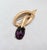 1960s textured goldtone loop with cabochon faux-amethyst brooch with security clasp. Marked crown "TRIFARI©" on the back....