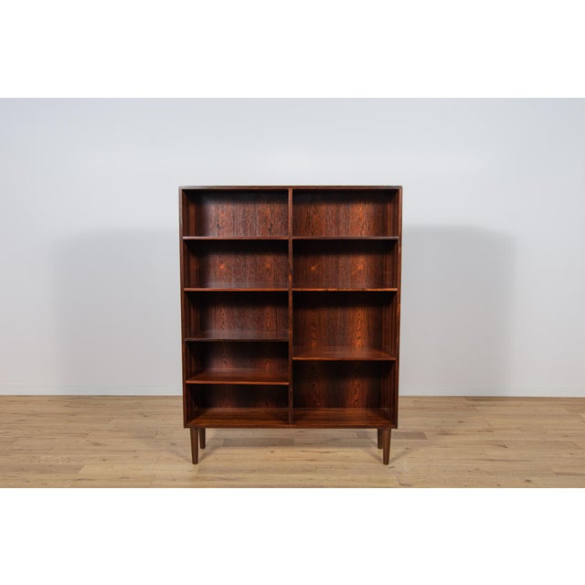 The shelf made of rosewood in Denmark in the 1960s. The shelf has interesting graining. Possibility to adjust the height...