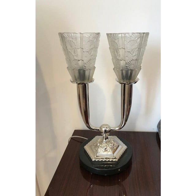 French Art Deco floral table lamp. Two clear frosted floral glass shades held by polished nickel frame sitting on black...