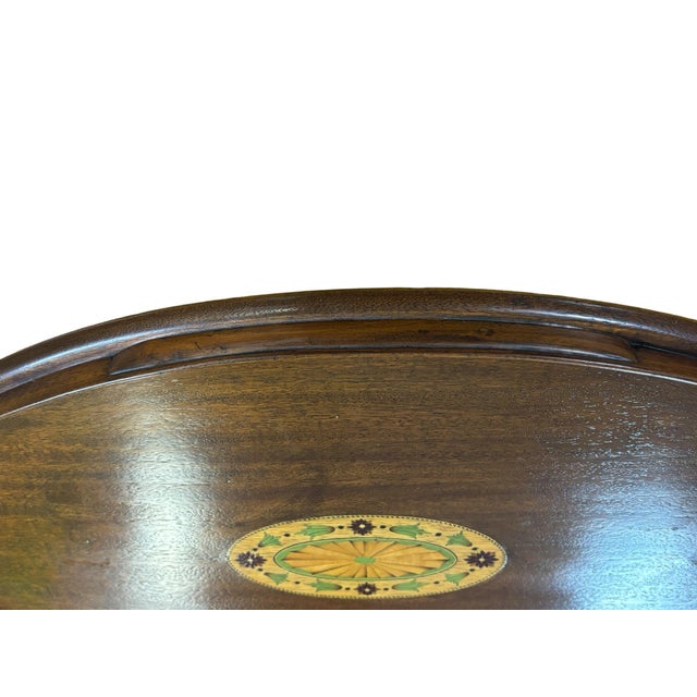 Elegant vintage mahogany serving tray featuring a detailed central marquetry medallion accented by floral and foliate...