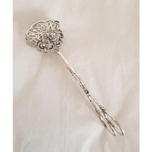 A refined pair of antique continental-style silver patisserie serving tongs, dating to the early 20th century and bearing...