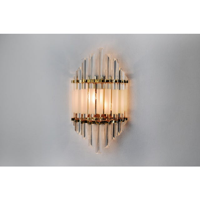 Very beautiful and large venini wall lamp produced in italy in the 70s. Triedi crystals supported by a gilded metal...