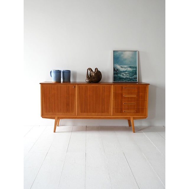 Teak sideboard with four drawers, hinged doors and double wood veneer in contrasting tones. Manufactured by Ulferts in the...