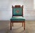 Antique Aesthetic Movement chair with needlepoint upholstered seat and backrest and hand carved detail. Casters on front...