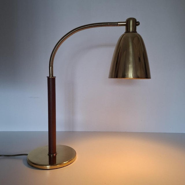 Elegant table lamp in the style of Josef Frank from the 1950s, with a shade and base made of polished brass. The curved,...