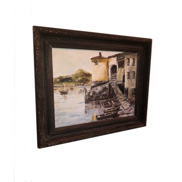 A vintage nautical painting of a French seaside fishing village. From France, in a dark wood frame.