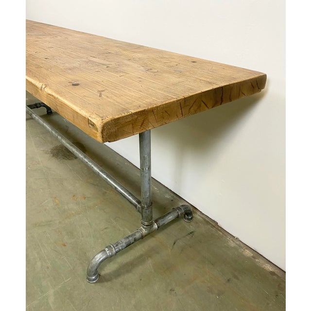Industrial dining table from 1960s. It features construction of iron pipes and solid wooden plate.The weight of the table...
