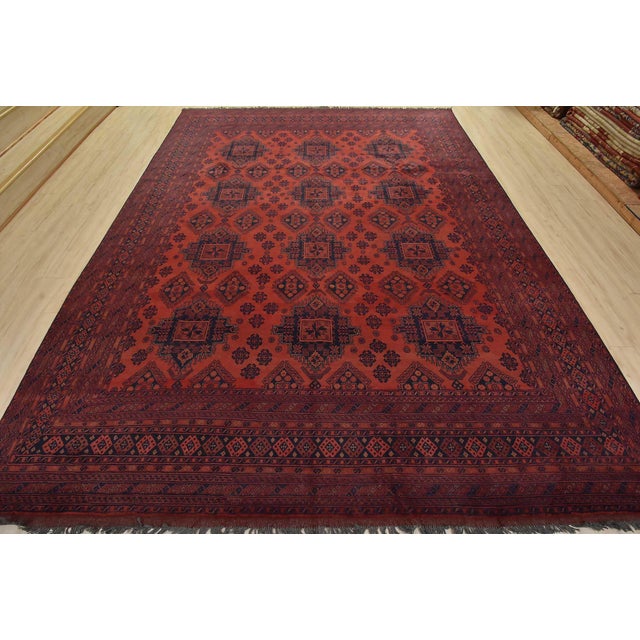A tribal Turkmen rug hand-knotted with fine wool and natural dyes. This nomadic rug features rows of geometric medallions...